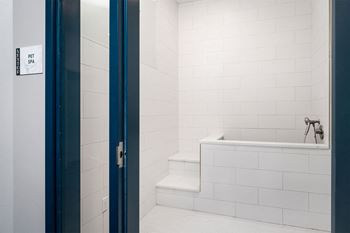 a bathroom with a tub and a toilet and a blue door